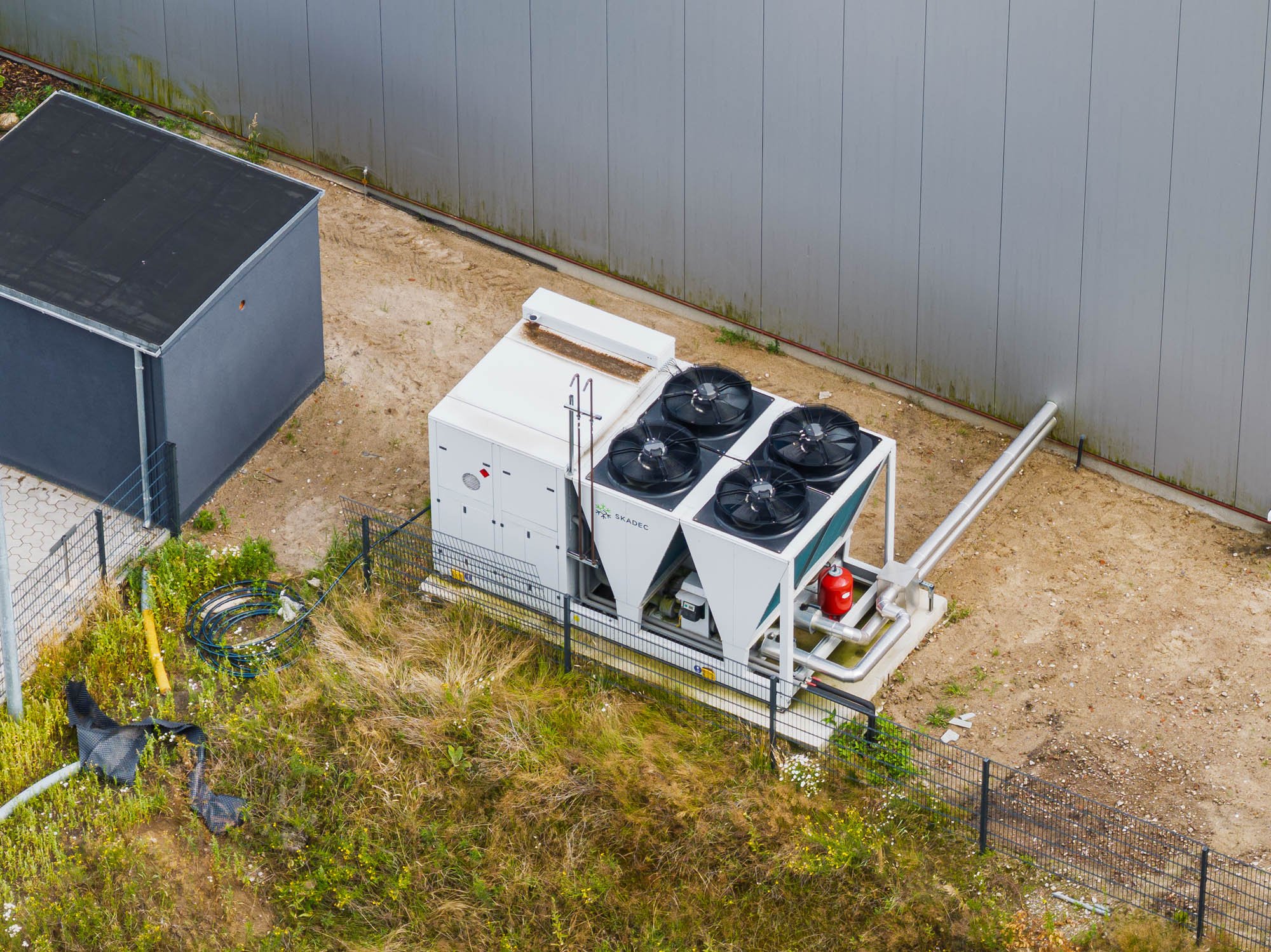 Außen aufgestellte Propan-Wärmepumpe mit Rohrleitungen zum Gebäude