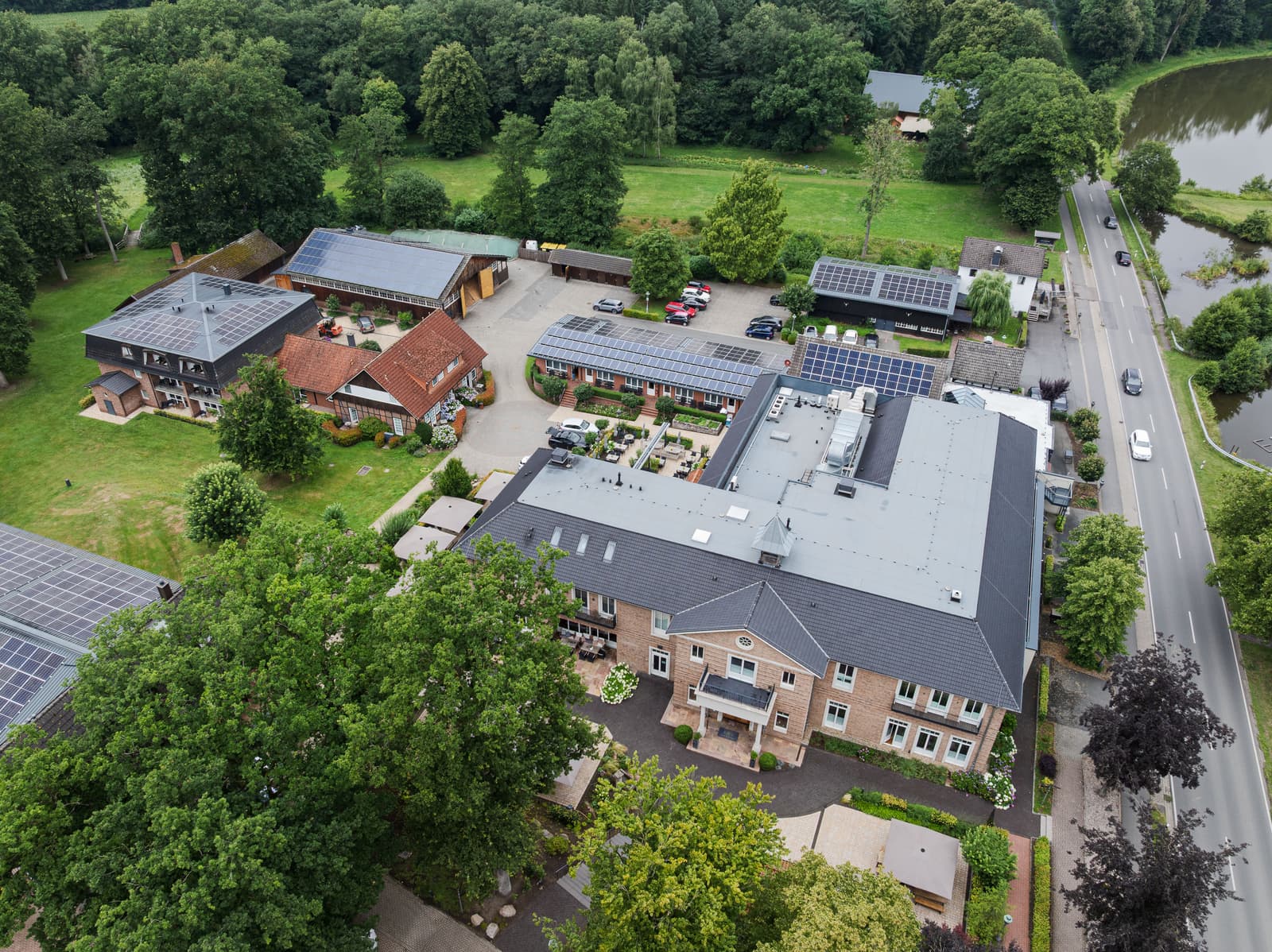 Luftbild der gesamten Anlage mit Haupthaus, Nebengebäuden und Parkplätzen