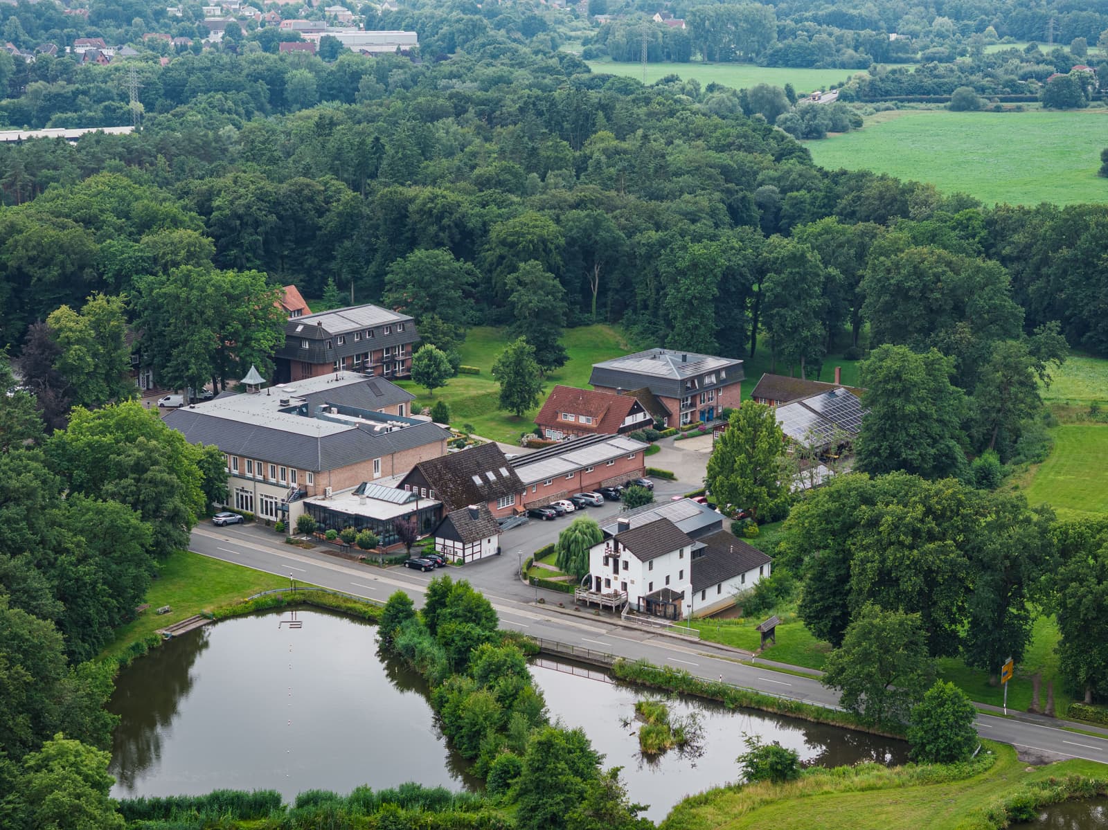 Luftbild: Gut Altona an der Straße, umgeben von Wald, im Vordergrund zwei Teiche